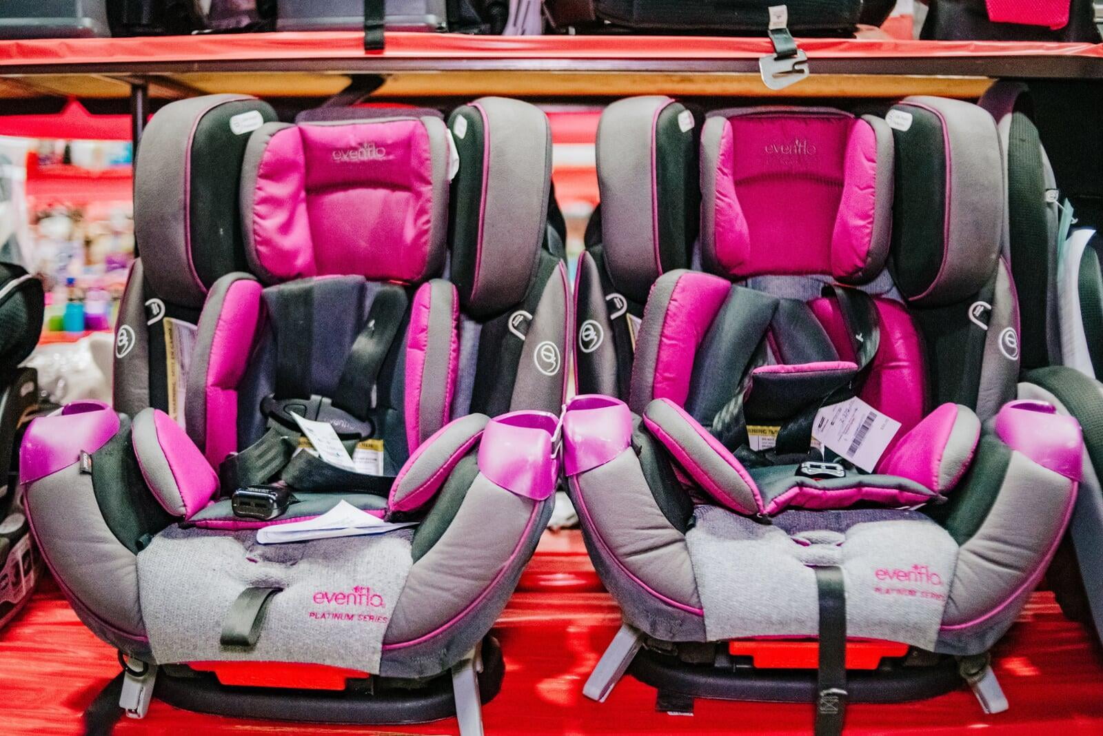 2 pink carseats on a table.