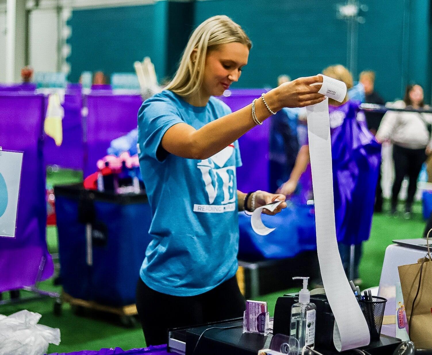 A JBF Team Member scanning clothing at the register.