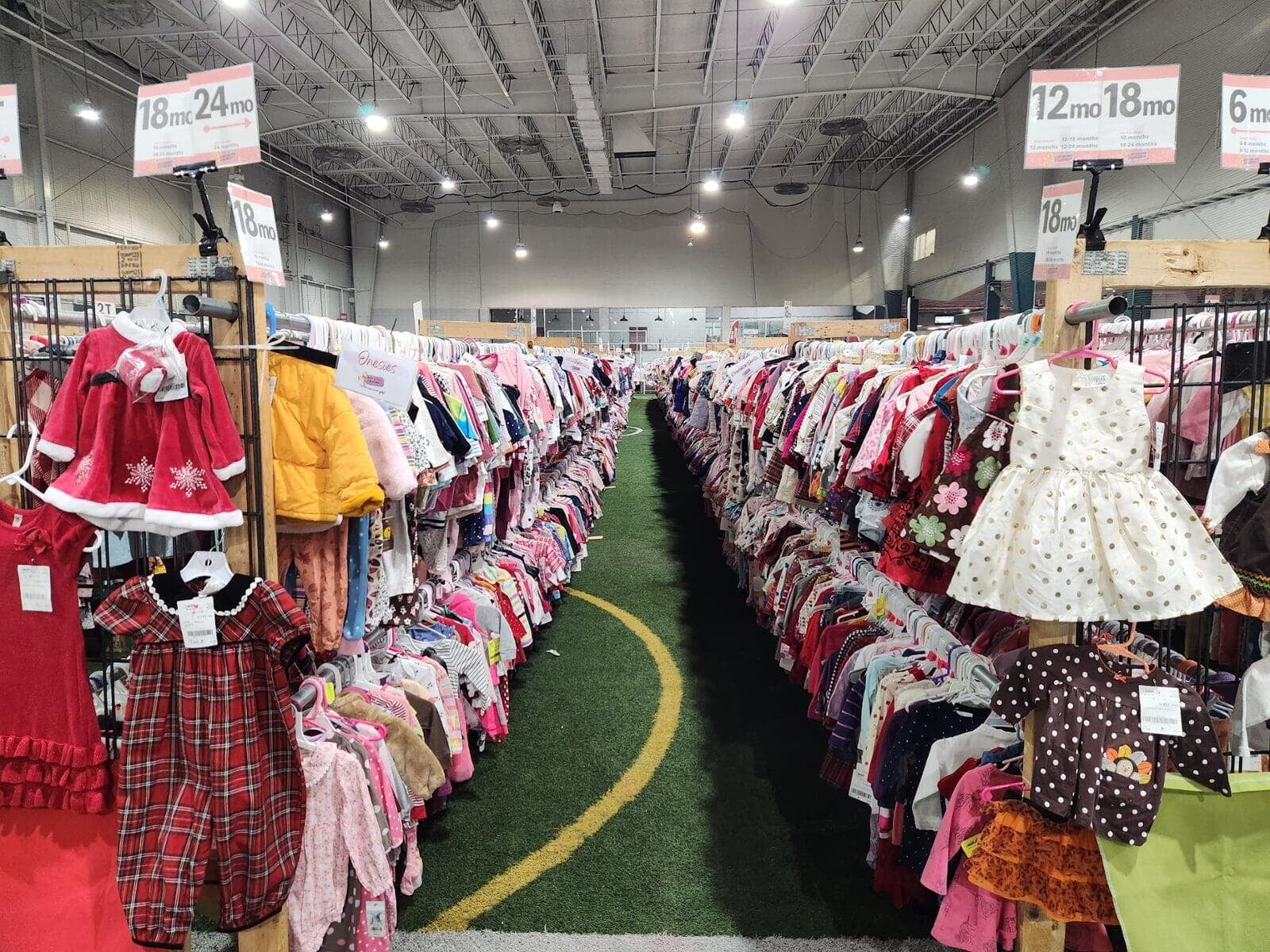 An indoor turf field holds racks of girls fall and winter clothing at the JBF sale.