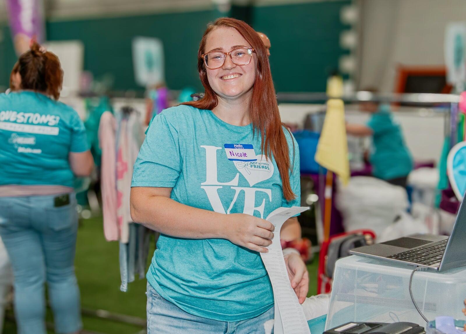 A woman smiles after checking out a customer at the cash registers.