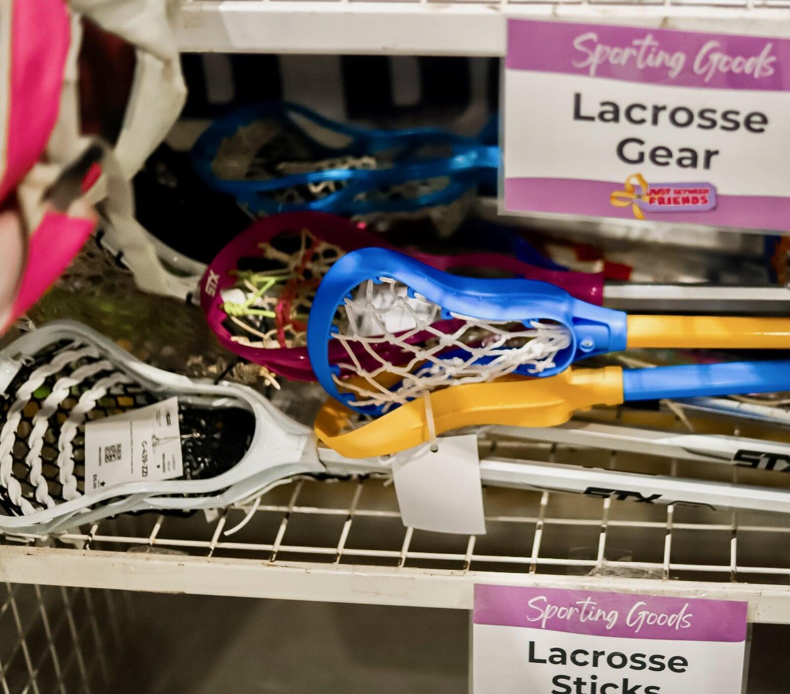 Lacrosse gear stacked on a white wire shelf